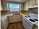 Kitchen with white appliances and wood-look floors at 6128 Topher Trl # 6128, Mulberry, FL 33860