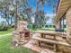 Relaxing patio with stone barbecue and wooden picnic table at 4070 Lake Marianna Dr, Winter Haven, FL 33880