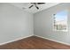 Bright bedroom with wood-look floors, ceiling fan, and window view at 10517 Mesa Ln, Clermont, FL 34711