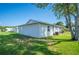 Single-story home with white siding, black window frames, and a well-maintained lawn at 4829 Colonnades E Cir, Lakeland, FL 33811