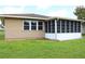 Tan house with a screened porch and a grassy yard at 608 Lark Dr, Lakeland, FL 33813