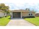 Tan one-story house with a covered carport and well-maintained lawn at 608 Lark Dr, Lakeland, FL 33813