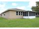 Tan house with a screened porch and a grassy yard at 608 Lark Dr, Lakeland, FL 33813