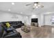 Open concept living room with sectional sofa, TV, and wood-look tile floors at 2233 20Th Nw St, Winter Haven, FL 33881