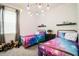 Bedroom with two twin beds, colorful bedding, and a window at 731 Griffon Ave, Lake Alfred, FL 33850