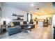 Open living room with a grey sectional sofa, coffee table, and kitchen view at 731 Griffon Ave, Lake Alfred, FL 33850