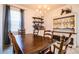 Bright dining room features a spacious table with wooden chairs, built-in hutch and window coverings at 731 Griffon Ave, Lake Alfred, FL 33850
