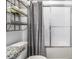 Bathroom with tub, shower, and gray striped curtain at 731 Griffon Ave, Lake Alfred, FL 33850
