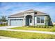 One-story home with gray exterior, stone accents, and a two-car garage at 731 Griffon Ave, Lake Alfred, FL 33850