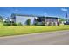 Single-wide manufactured home with screened porch and landscaped yard at 5002 Lodgewood Dr, Lakeland, FL 33810