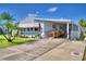 Cute Florida mobile home with carport, ramp, and landscaped yard at 5002 Lodgewood Dr, Lakeland, FL 33810
