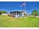 Single-wide manufactured home with screened porch and American flag at 5002 Lodgewood Dr, Lakeland, FL 33810