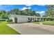 Front view of a ranch home with a white garage door and well-manicured lawn at 1175 E George St, Bartow, FL 33830
