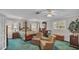 Main bedroom with a four-poster bed, two armchairs, and green carpeting at 1175 E George St, Bartow, FL 33830