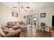 Living room features hardwood floors, comfortable seating, and access to a screened lanai at 941 Devonshire Way, Lake Wales, FL 33853