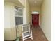 Inviting entryway with a red door and rocking chair at 2356 Lake James Way, Lakeland, FL 33810