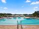 Resort-style pool with lake view and lounge chairs at 2356 Lake James Way, Lakeland, FL 33810