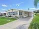 Light beige manufactured home with carport at 134 Lake Hazel Dr, Winter Haven, FL 33884