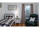 Bright bedroom with hardwood floors, a window with curtains, and a relaxing chair at 1806 17Th Nw St, Winter Haven, FL 33881