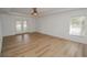 Spacious bedroom with wood-look floors, ceiling fan, and large window at 300 Winona Ct, Auburndale, FL 33823