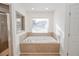 Bathroom with a jetted bathtub and window at 300 Winona Ct, Auburndale, FL 33823