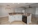 Modern kitchen with a large island, white cabinets, and black appliances at 300 Winona Ct, Auburndale, FL 33823