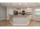 Modern kitchen with white cabinets, black appliances, and an island at 300 Winona Ct, Auburndale, FL 33823