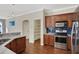 Modern kitchen with wood cabinets, blue tile backsplash, and stainless steel appliances at 109 Costa Loop, Auburndale, FL 33823
