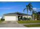 Single-story home with attached garage, palm trees, and manicured lawn at 1015 Highland Crest Cir, Lake Wales, FL 33853