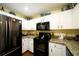 Modern kitchen with black appliances and granite countertops at 1015 Highland Crest Cir, Lake Wales, FL 33853