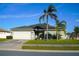 House exterior featuring a two-car garage, landscaped lawn, and palm trees at 1015 Highland Crest Cir, Lake Wales, FL 33853