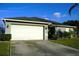 Exterior view of a house with a white garage door and landscaping at 1015 Highland Crest Cir, Lake Wales, FL 33853