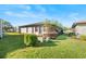 Rear view of a single-story house with a well-maintained lawn and landscaping at 4904 Goldenview Ln, Lakeland, FL 33811