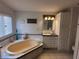 Bathroom with an oval bathtub, white vanity, and tile accents at 1744 Quail Hill Dr, Lakeland, FL 33810