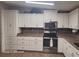 Modern kitchen featuring white cabinets, stainless steel appliances, and tile flooring at 1744 Quail Hill Dr, Lakeland, FL 33810