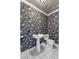 Small powder room with pedestal sink and patterned wallpaper at 83 Shadow Ln, Lakeland, FL 33813