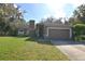 Brown house with a two-car garage and manicured lawn at 129 Homewood Dr, Winter Haven, FL 33880