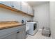 Laundry room with gray cabinets, wood counter, and washer/dryer at 7929 Lake James Blvd, Lakeland, FL 33810