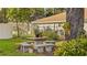 Cozy patio with stone table and benches, nestled in a lush, fenced backyard at 1215 Cypress E Pt, Winter Haven, FL 33884