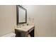 Simple bathroom with dark wood vanity and a framed mirror at 1215 Cypress E Pt, Winter Haven, FL 33884