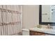 Bathroom with beige shower curtain and wood vanity at 1215 Cypress E Pt, Winter Haven, FL 33884