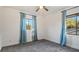 Well-lit bedroom featuring grey carpet and two windows with blue curtains at 1215 Cypress E Pt, Winter Haven, FL 33884