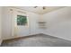 Bedroom featuring grey carpet, a window with white curtains, and corner shelving at 1215 Cypress E Pt, Winter Haven, FL 33884