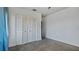 Bright bedroom with grey carpet, built-in shelving, and window with blue curtains at 1215 Cypress E Pt, Winter Haven, FL 33884