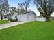 Side view of the house showcasing the gray siding and a white fence at 5225 Golden Gate Blvd, Polk City, FL 33868