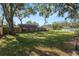 Large backyard with lush grass, mature trees, and wooden fence at 5860 E Starling Dr, Mulberry, FL 33860