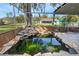 Screened-in pond with waterfall feature and stonework at 5860 E Starling Dr, Mulberry, FL 33860