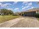 View of the home's driveway and garage, plus a glimpse of the neighborhood at 6789 Ashbury Dr, Lakeland, FL 33809