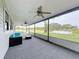 Screened porch with a teal couch and view of the backyard at 92 Wood Hall Dr, Mulberry, FL 33860