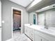Bathroom with double vanity, white cabinets, and marble-look flooring at 92 Wood Hall Dr, Mulberry, FL 33860